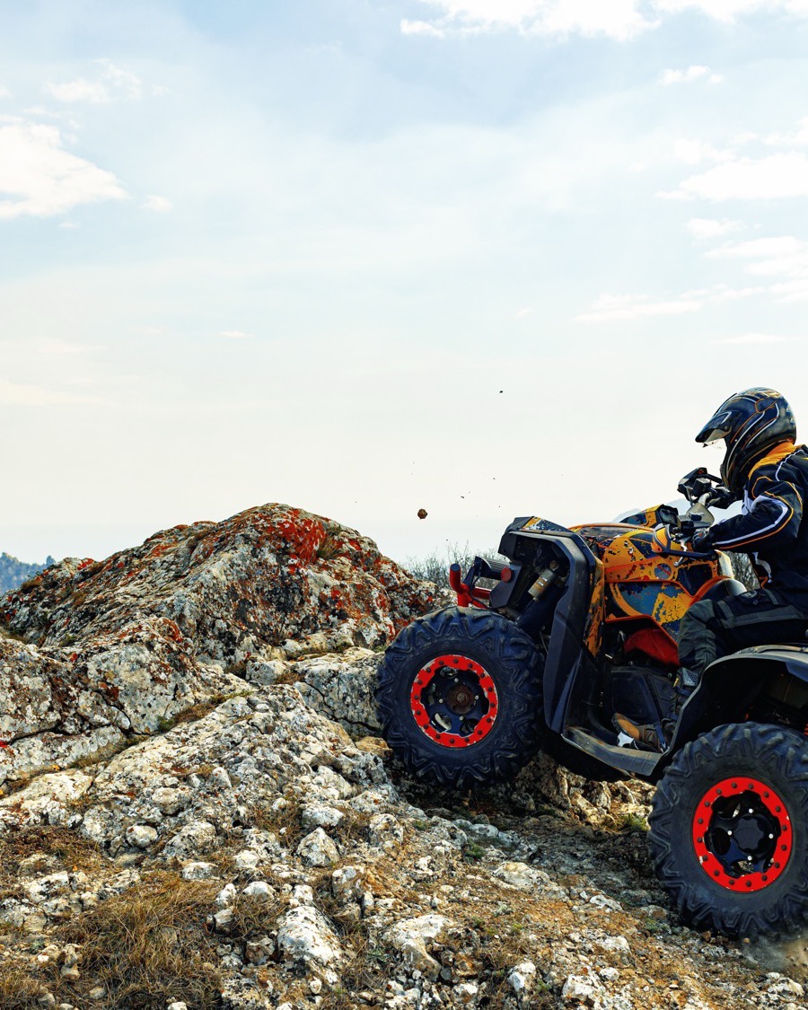 Rider being handed a safety helmet at the camp before the start of a guided ATV tour in Pattaya