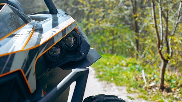 Front end of an off-road buggy with roll cage on a forest trail