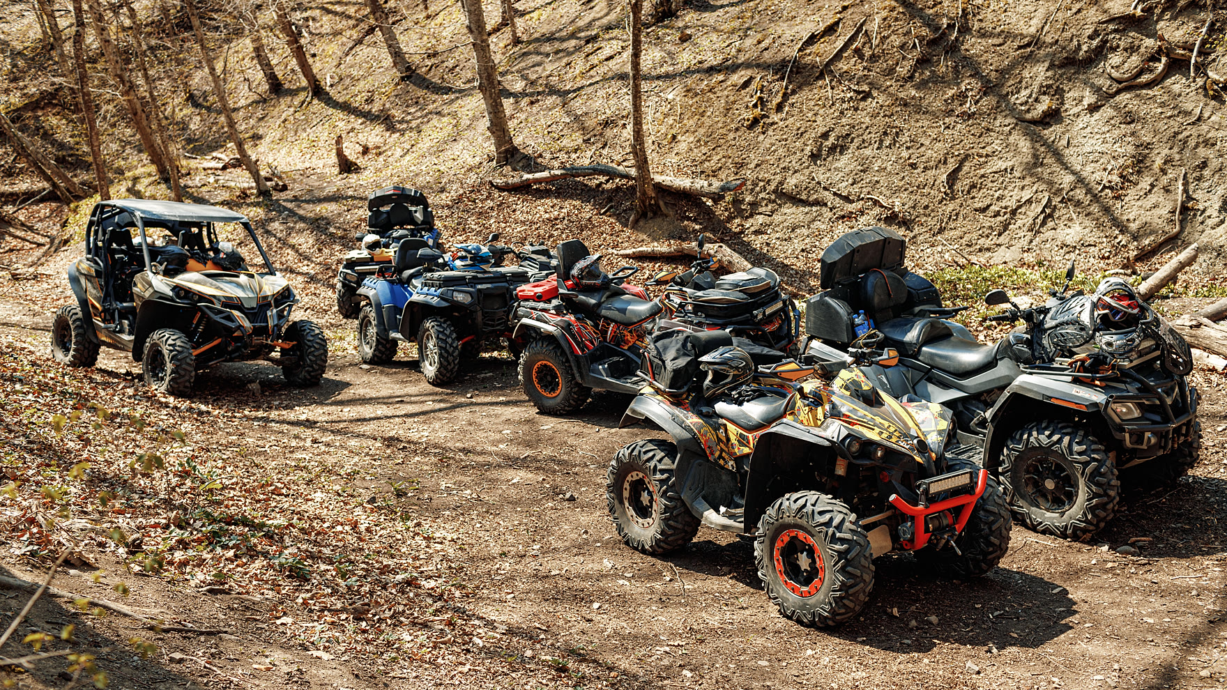 Quad bikes and off-road buggies lined up on a dirt trailhead before the first departure of the day
