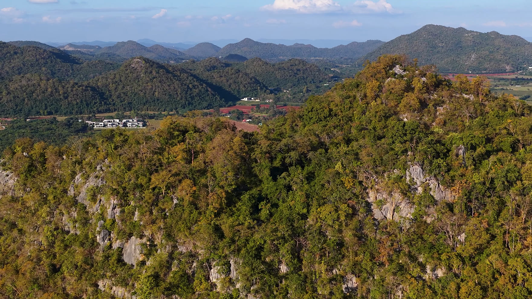 Forested limestone ridge looking out over green hills and farmland inland from Pattaya, the kind of high ground the jungle ATV trail climbs to